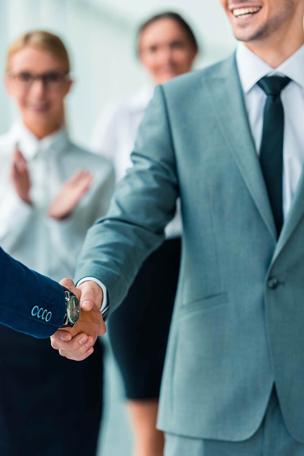 Commercial Lawyers Melbourne 1 Professional Handshake Between Two Businesspeople, With Colleagues Clapping In The Background.
