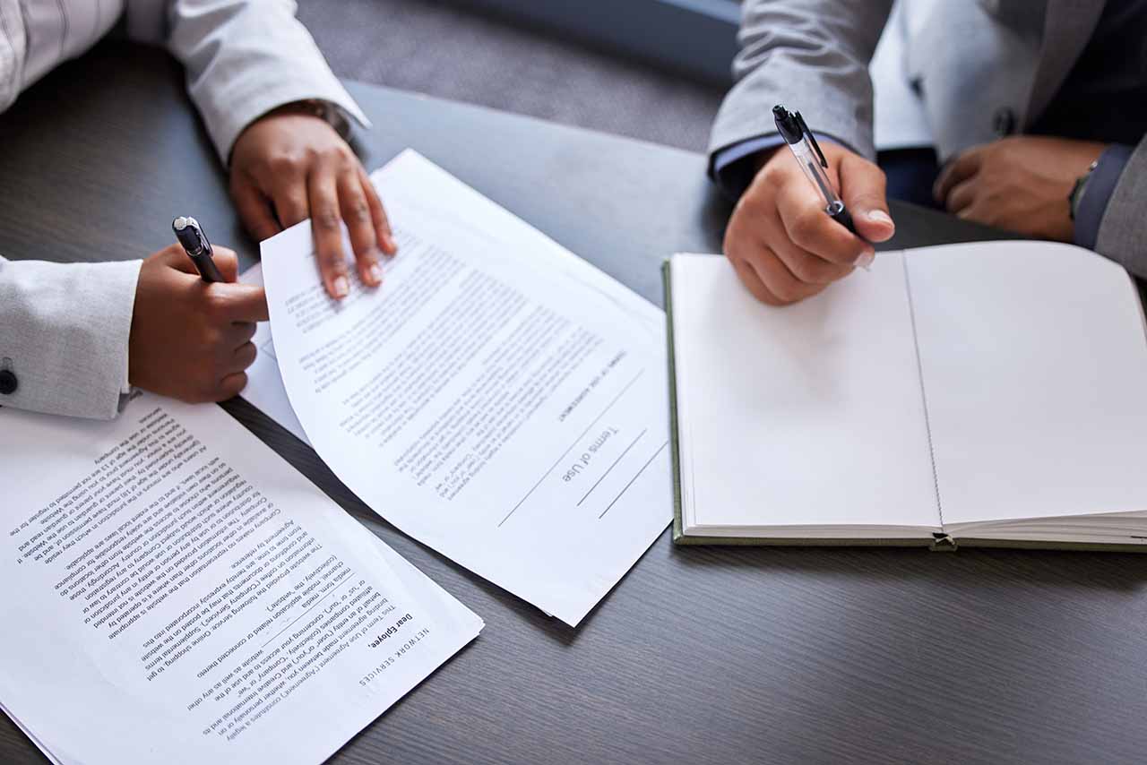 Business Lawyers In Melbourne 7 Professionals Negotiating A Business Contract With Documents And Notes.