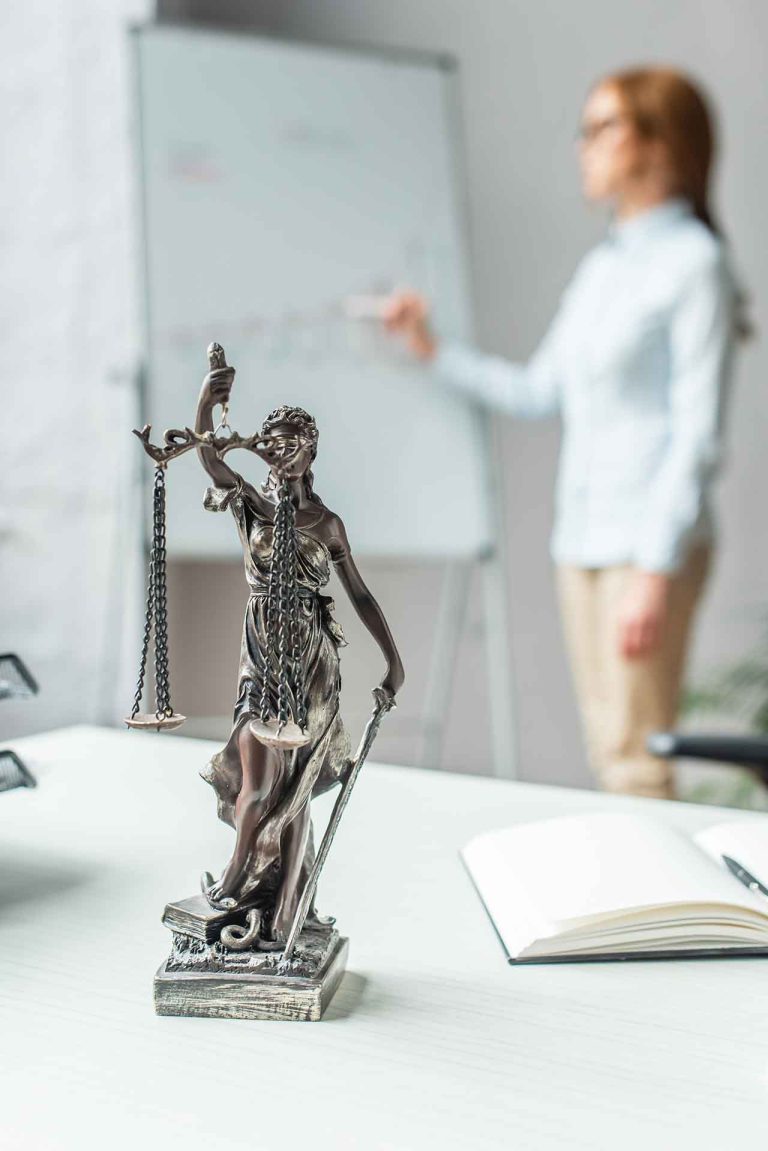 Hire a Solicitor in Melbourne – Lady Justice statue and a professional solicitor at work.
