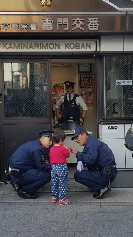 a group of police officers standing in front of a child
